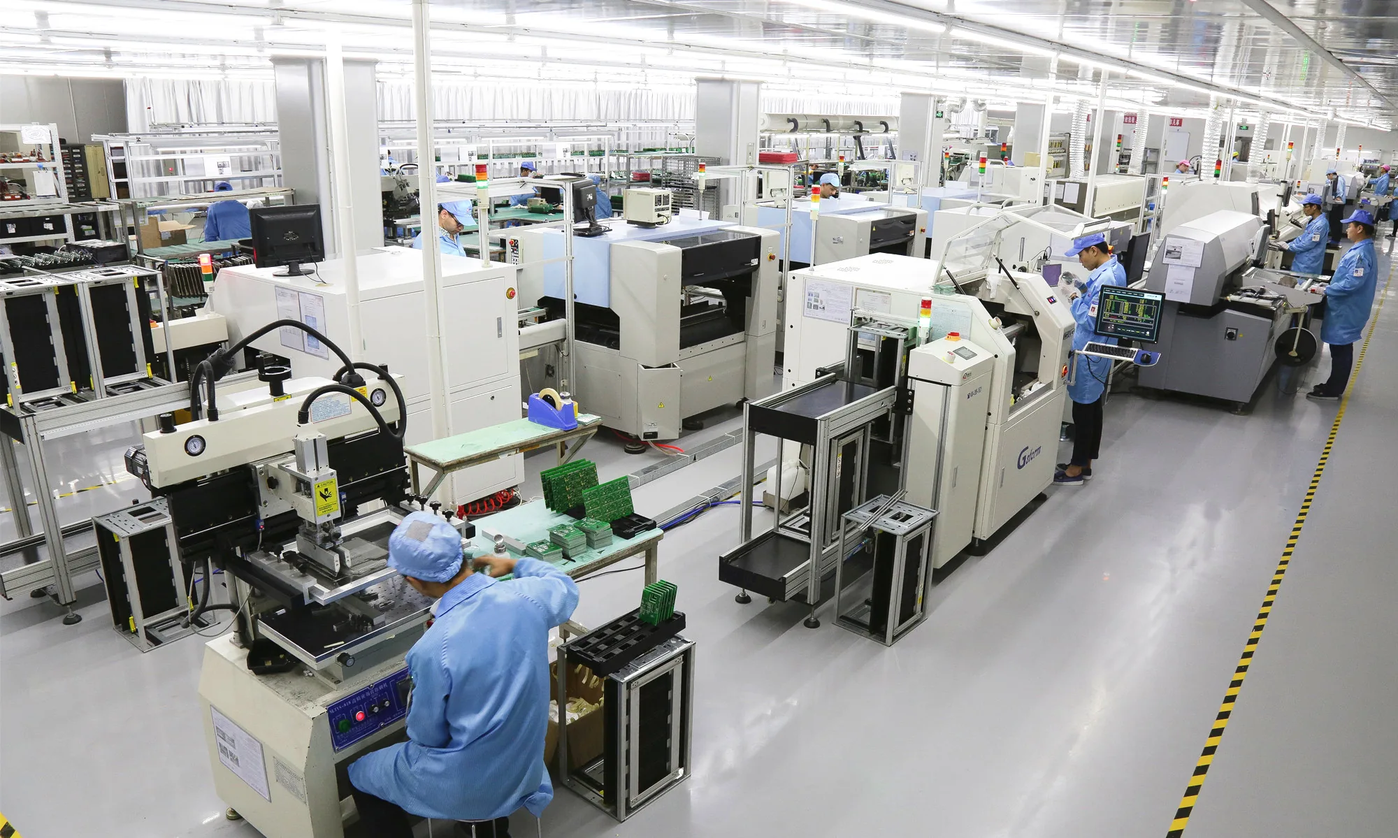 SMT assembly line with pick-and-place machines and operators at a PCB assembly plant